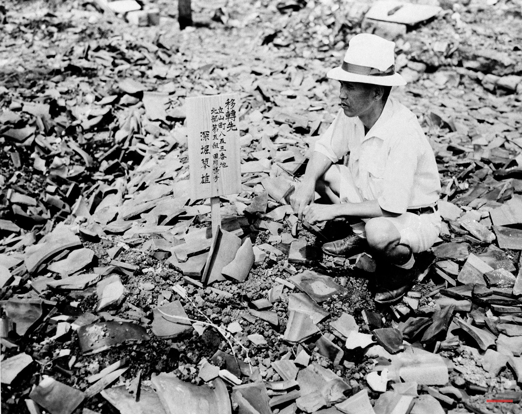  A civilian examines a sign in the middle of mass of rubble that once was a home in Nagasaki, Sept 14, 1945, one of the cities destroyed by atomic bomb.  (AP Photo) 