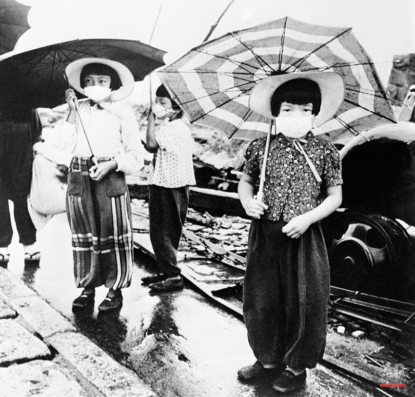  The Japanese of atom-bombed Hiroshima have put the ancient custom of wearing nose and mouth masks while out of doors to a good use. Hiroshima was the first town to be hit by an atom bomb during the war. Japanese girls wearing their masks as they wal