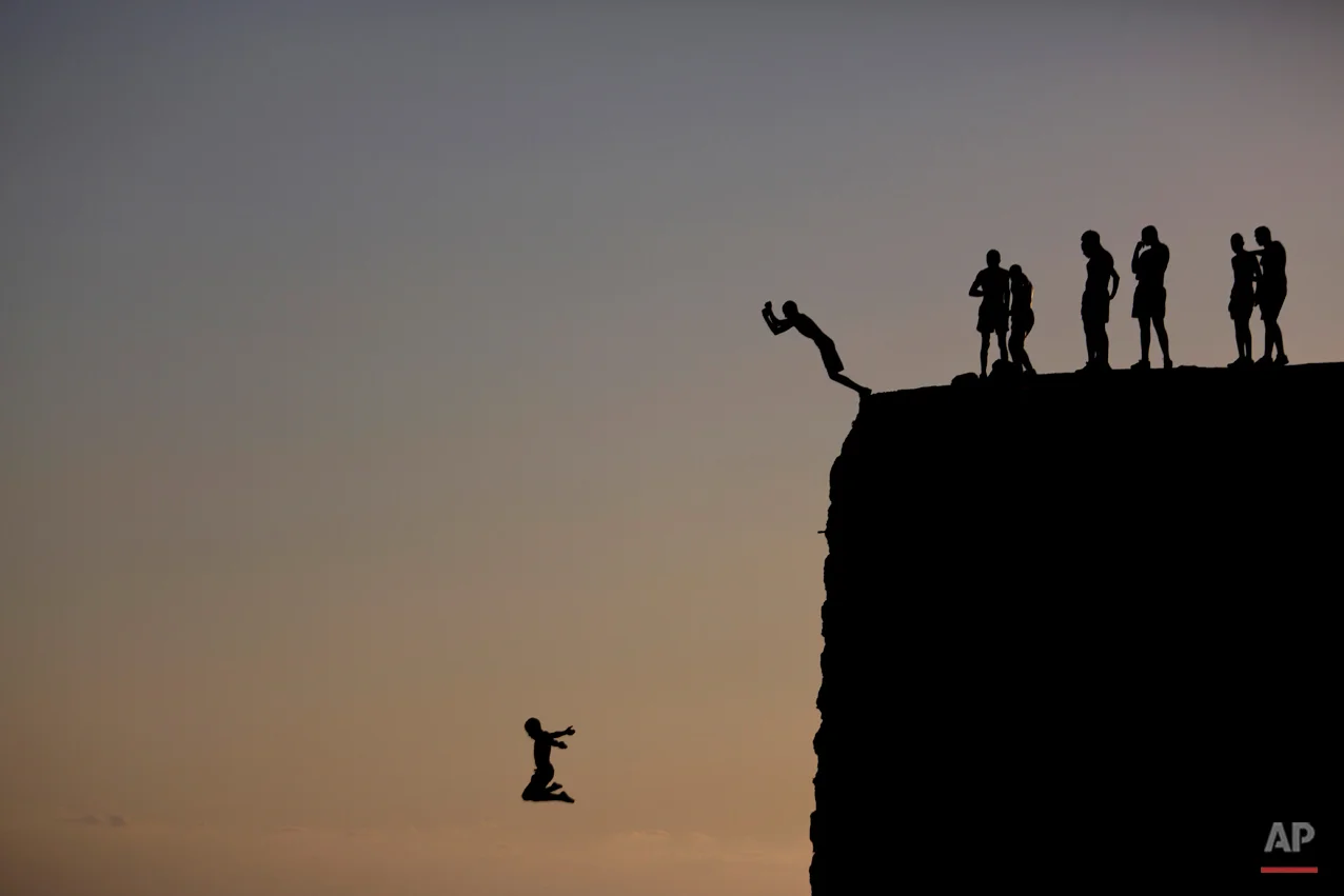 Israeli Arab boys jump into the Mediterranean sea from the ancient wall surrounding the old city of Acre, northern Israel, Monday, Aug. 31, 2015. (AP Photo/Ariel Schalit)