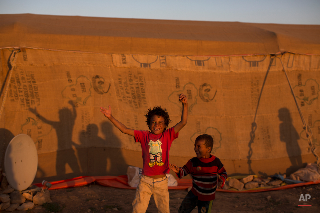  Syrian refugee children react in front of the camera while playing at an informal tented settlement near the Syrian border on the outskirts of Mafraq, Jordan, Tuesday, Aug. 25, 2015. (AP Photo/Muhammed Muheisen) 