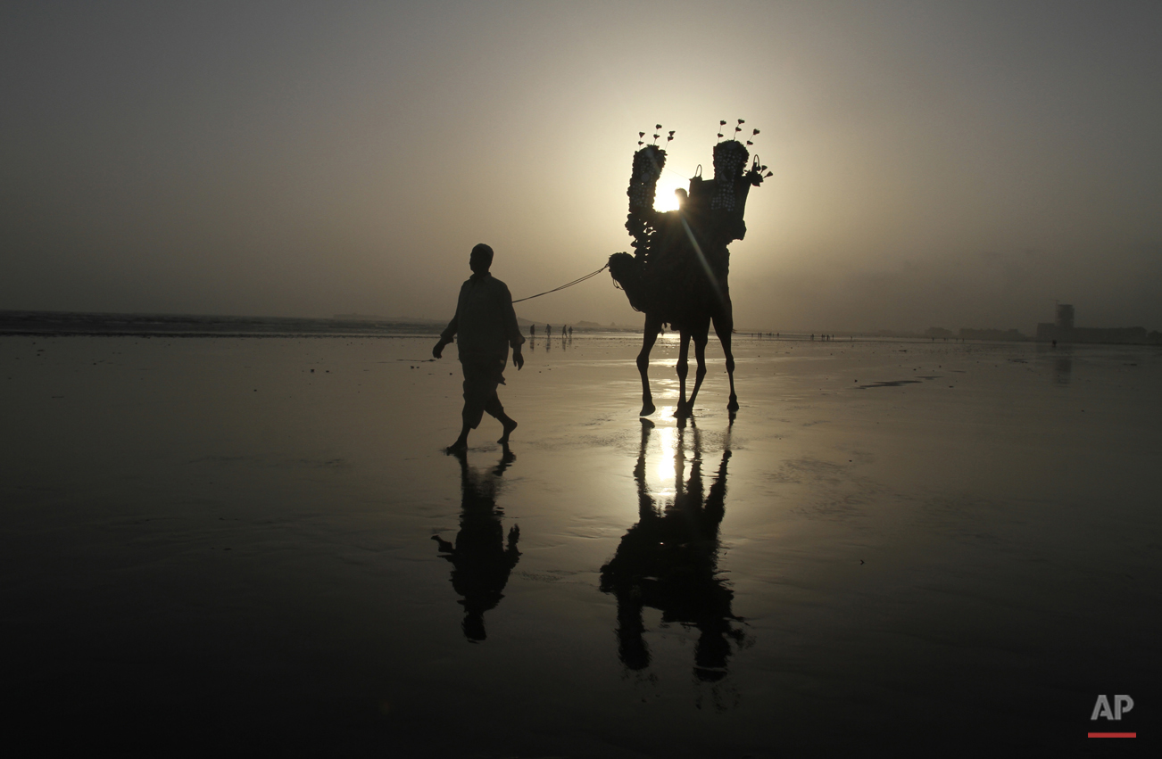  A Pakistani family enjoy a camel ride at the Karachi beach, in Pakistan, Tuesday, Aug. 4, 2015 in Pakistan. (AP Photo/Fareed Khan) 