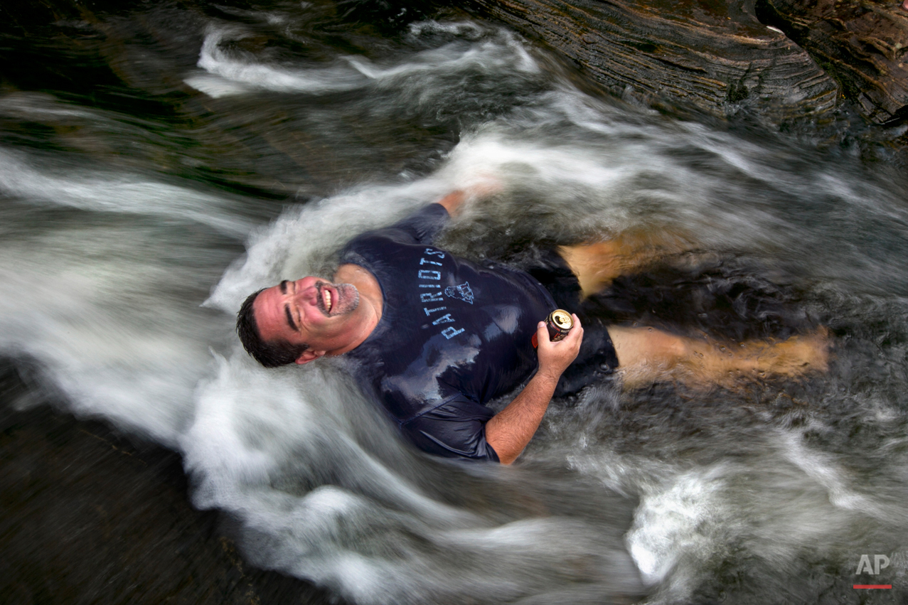  Troy Munford soaks in the waters of Sunday River in Riley Township, Maine, Wednesday, Aug. 19, 2015. Munford, a tour and travel sales manager at the Sunday River Ski Resort, and many of his co-workers were enjoying an afternoon escape from work to b