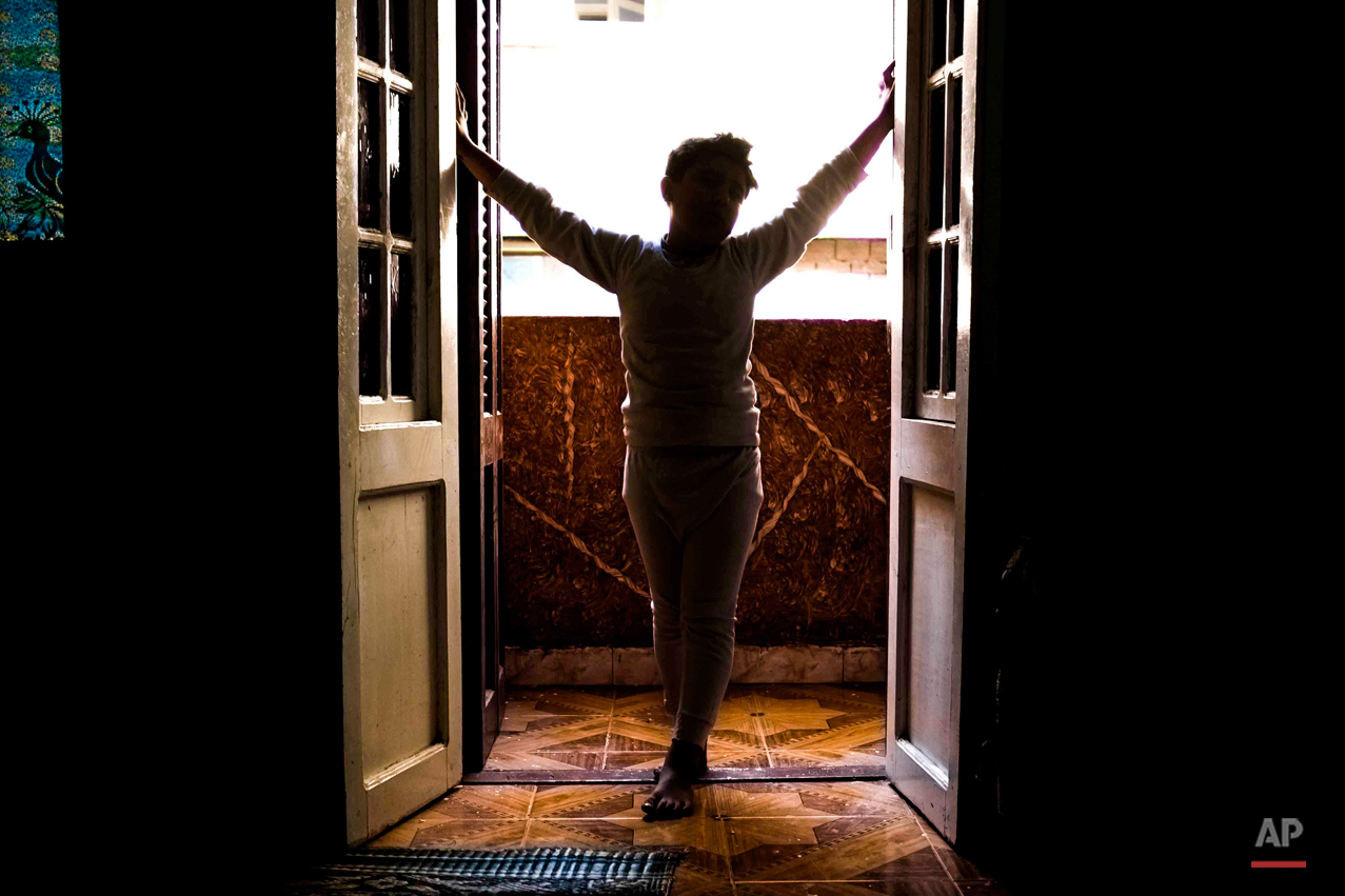  In this picture taken Feb. 8, 2015, 10-year-old Abanoub Samaan Nazmy stands on the balcony at his home in the Manshiet Nasr neighborhood of Cairo, Egypt. Abanoub lost his father to suspected military snipers as he protested in March 2011 over the bu