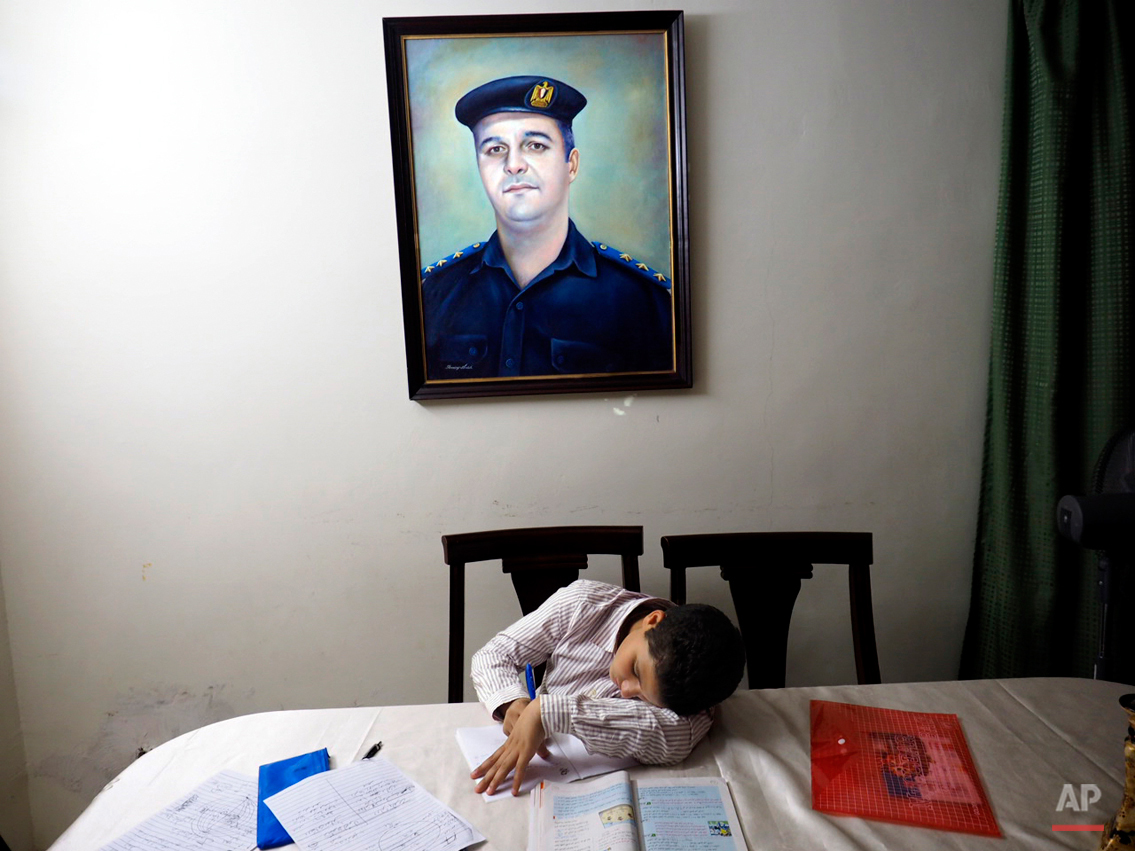  In this picture taken on Oct. 17, 2014, 13-year-old Adham Ehab Anwar, whose policeman father was shot to death in an attack on his station after the bloody security force breakup of Islamist sit-ins in Cairo in 2013, studies geometry at his home in 