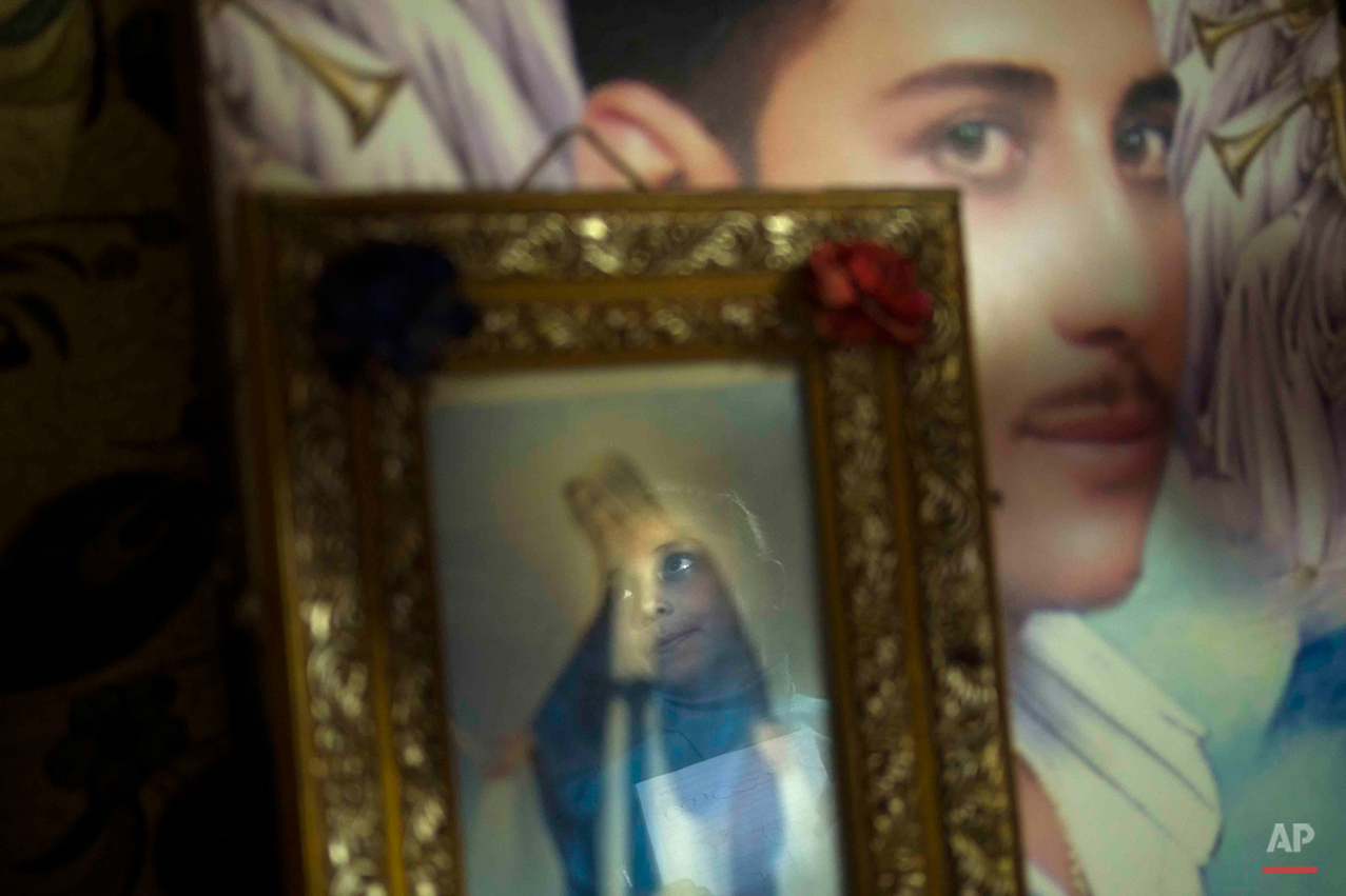  In this picture taken pn Feb. 2, 2015, 9-year-old Youstina Malak Rasmy, who lost her father to suspected military snipers as he protested in March 2011 over the burning of a church, looks at a portrait of him that hangs in her home in the Manshiet N