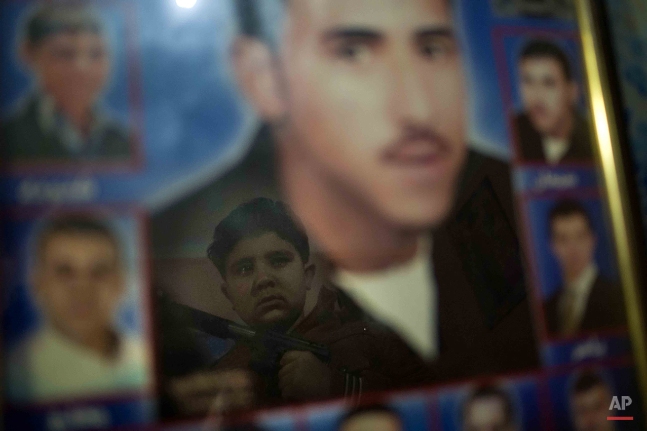  In this picture taken on Feb. 2, 2015, 10-year-old Abanoub Samaan Nazmy tears up as he holds a toy gun while he looks at the portrait of his father, at his home in the Manshiet Nasr neighborhood of Cairo, Egypt. Abanoub lost his father to suspected 