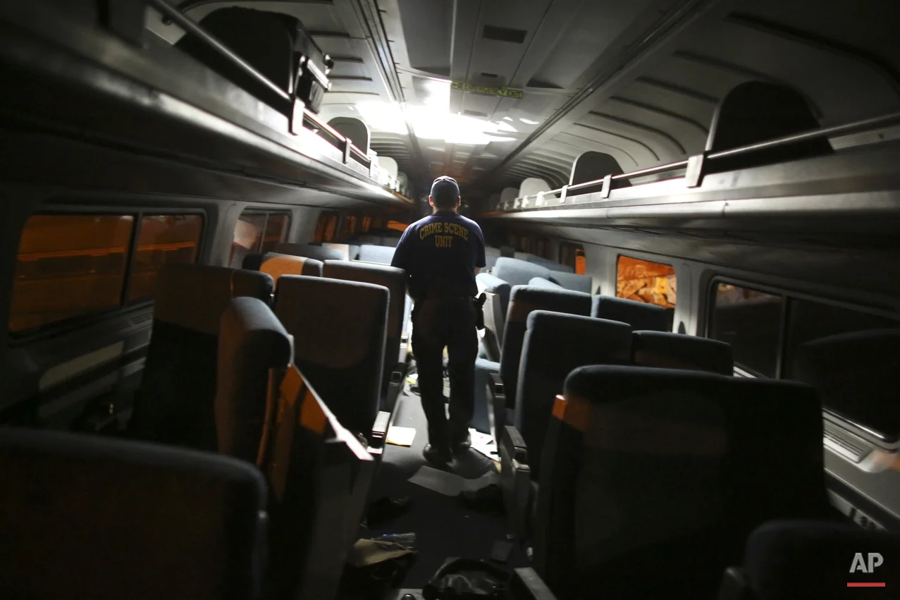 A crime scene investigator looks inside a train car after a Amtrak train wreck, Tuesday, May 12, 2015, in Philadelphia. (AP Photo/Joseph Kaczmarek)