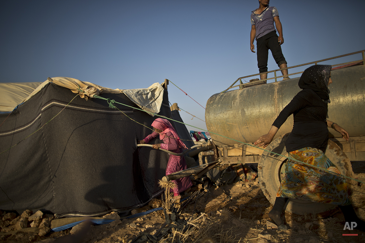  In this Saturday, July 25, 2015 photo, a Syrian refugee girl fills water from a tanker to her tent at an informal tented settlement near the Syrian border on the outskirts of Mafraq, Jordan. Aid agencies asked for $4.5 billion for 2015 to help refug