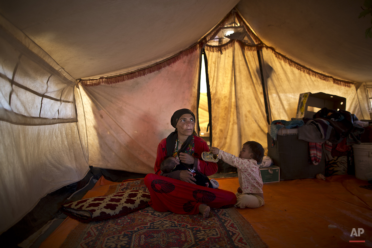  In this Sunday, July 26, 2015 photo, Syrian refugee Wazeera Elaiwi, 29, breast-feeds her newly born son Mohammed, 43 days, inside her tent at an informal settlement near the Syrian border on the outskirts of Mafraq, Jordan. Aid agencies asked for $4