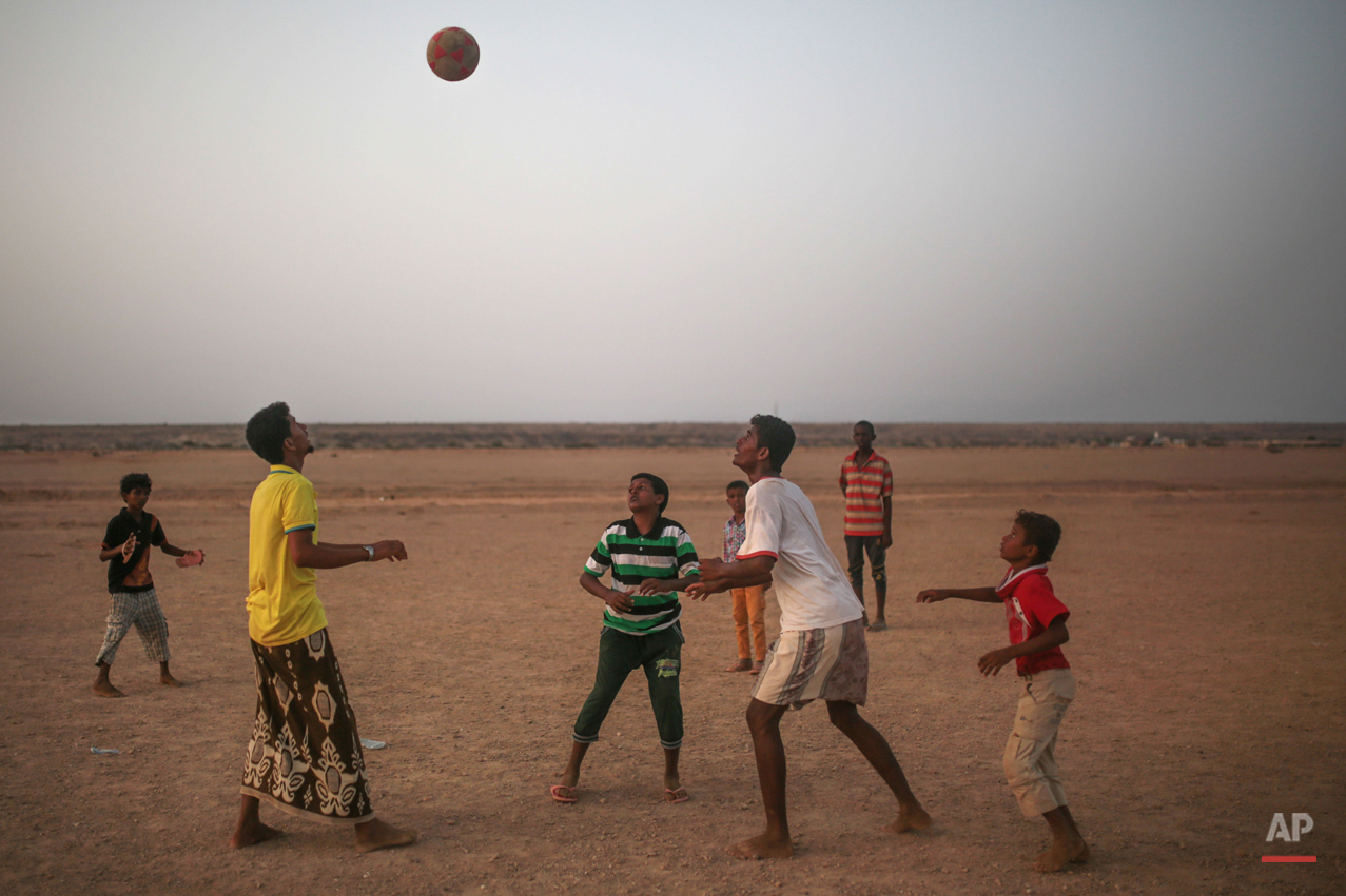  In this Wednesday, May 20, 2015 photo, Yemeni refugees play football outside the Markaze refugee camp where Yemeni refugees are stationed, in Obock, northern Djibouti. Many of the refugees are relieved to have escaped after two months of Saudi-led a