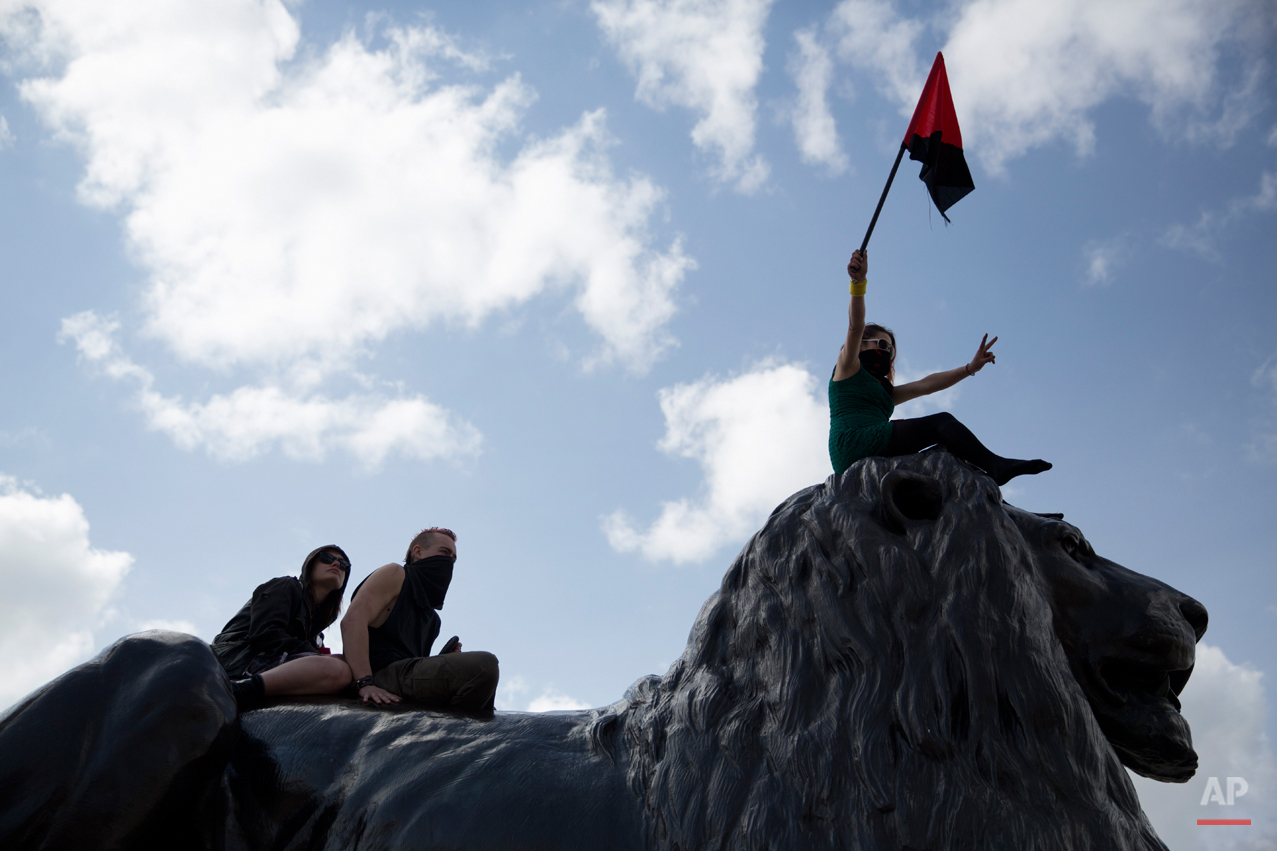  Protesters sit on top of one of the lion statues during a rally at the end of a May Day demonstration march in Trafalgar Square in London, Friday, May 1, 2015. Tens of thousands of workers marked May Day in European cities with a mix of anger and gl