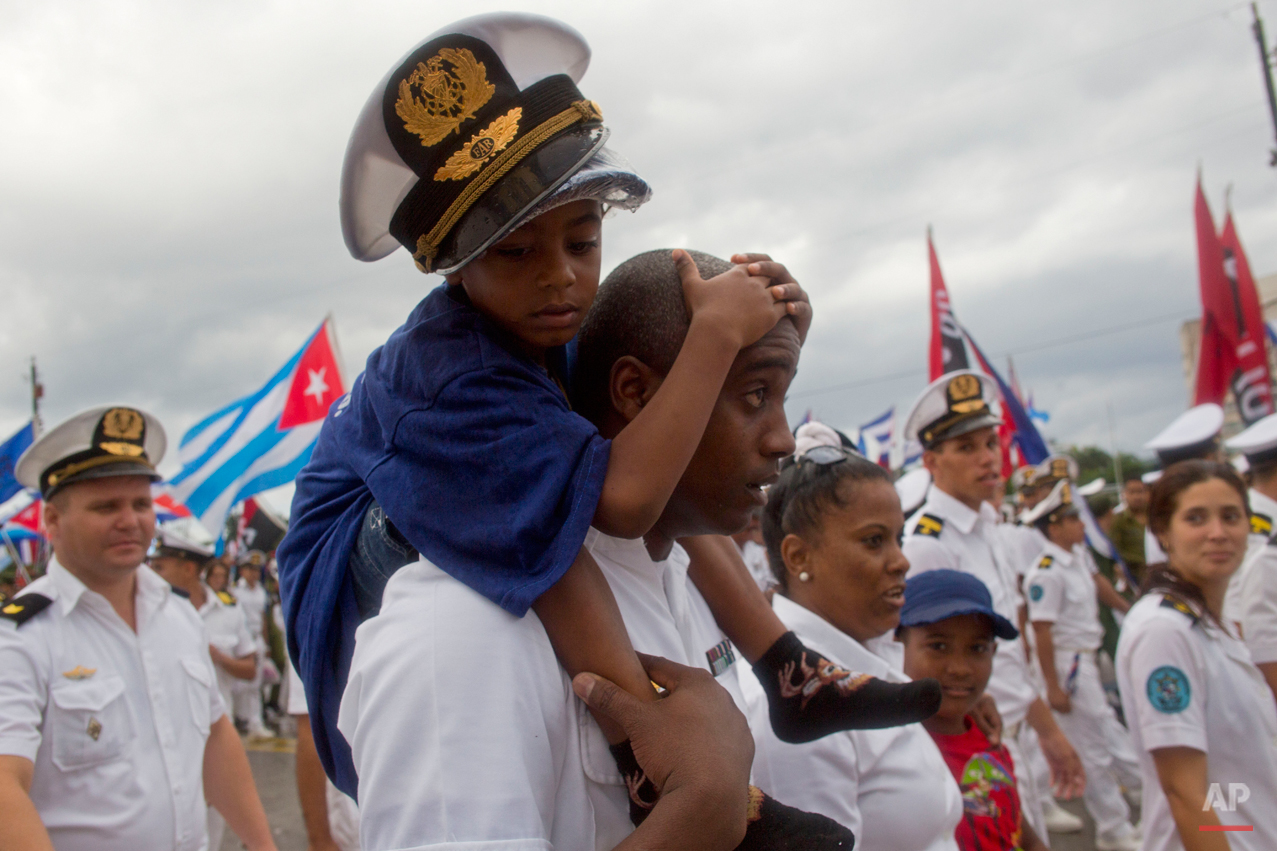  A Cuban Navy soldier carries a child on his shoulders as they march in Revolution Square marking May Day, in Havana, Cuba, Friday, May 1, 2015. Thousands of people converged on the plaza for the traditional march, led this year by President Raul Cas