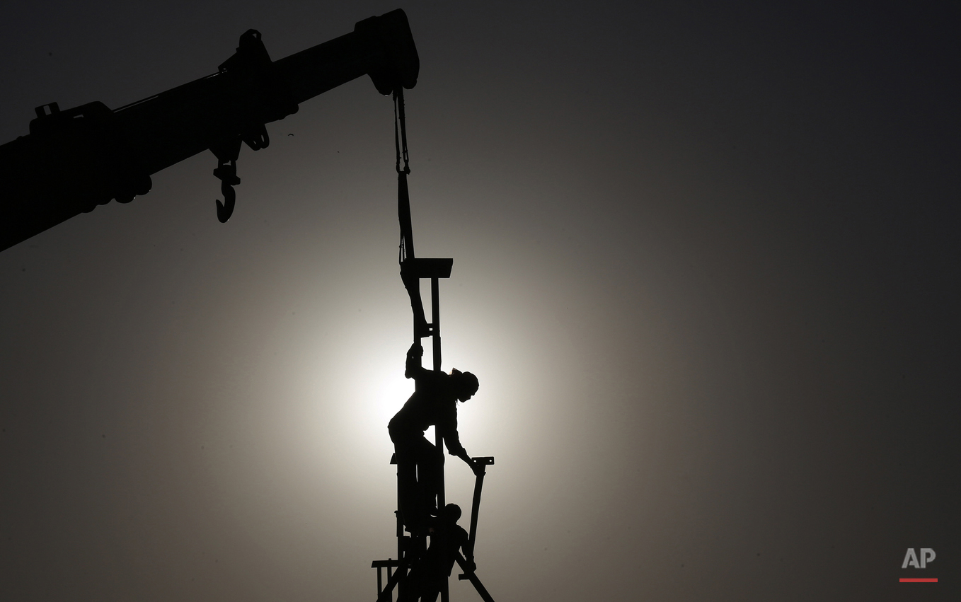  Indian laborers are seen silhouetted as they dismantle a temporary structure in Hyderabad, India, Friday, May 1, 2015. May 1 is marked as the International Labor Day or May Day across the world. (AP Photo/Mahesh Kumar A.) 