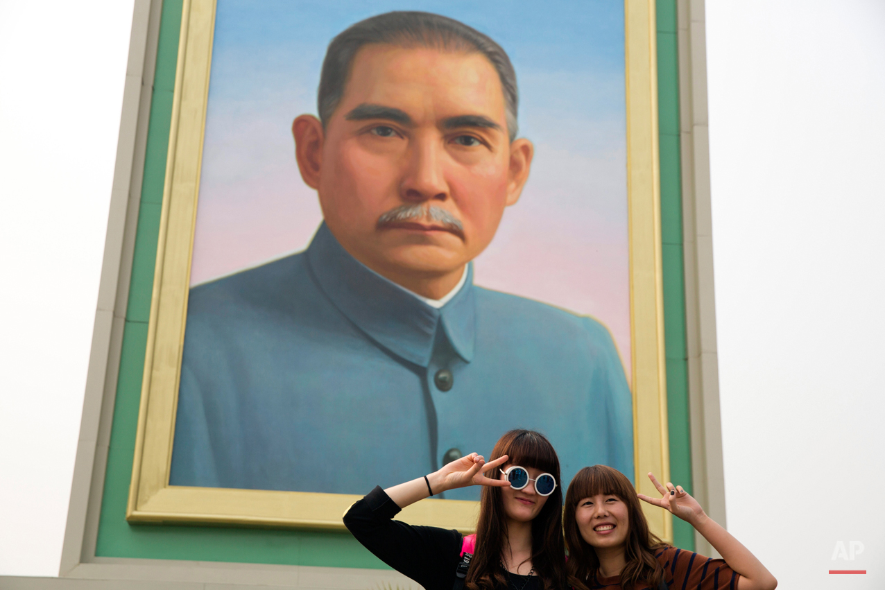  Visitors pose for photos near a portrait of Sun Yat-sen, who is widely regarded as the founding father of modern China, displayed for the May Day holidays on Tiananmen Square in Beijing Friday, May 1, 2015. Millions of Chinese are taking advantage o