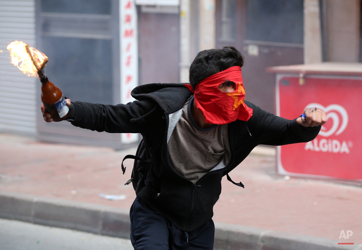  A demonstrator runs to hurl a firebomb towards riot police officers during clashes in Istanbul, Turkey, Friday, May 1, 2015.  Clashes erupted between police and May Day demonstrators in Istanbul on Friday as crowds determined to defy a government ba