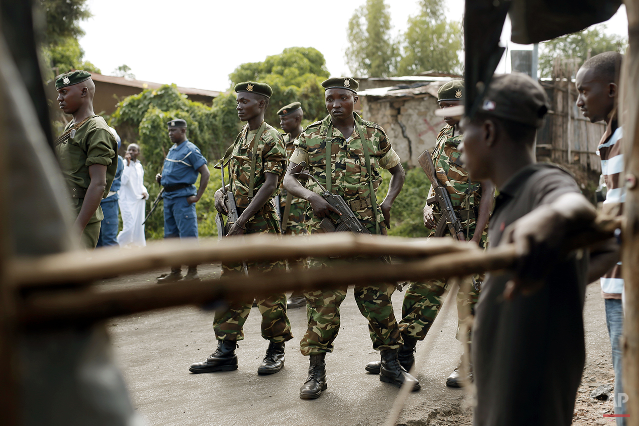  Burundi soldiers act as a buffer between demonstrator and police in Bujumbura, Burundi, Wednesday, April 29, 2015. Anti-government street demonstrations continued for a fourth day after six people died in protests against the move by President Pierr