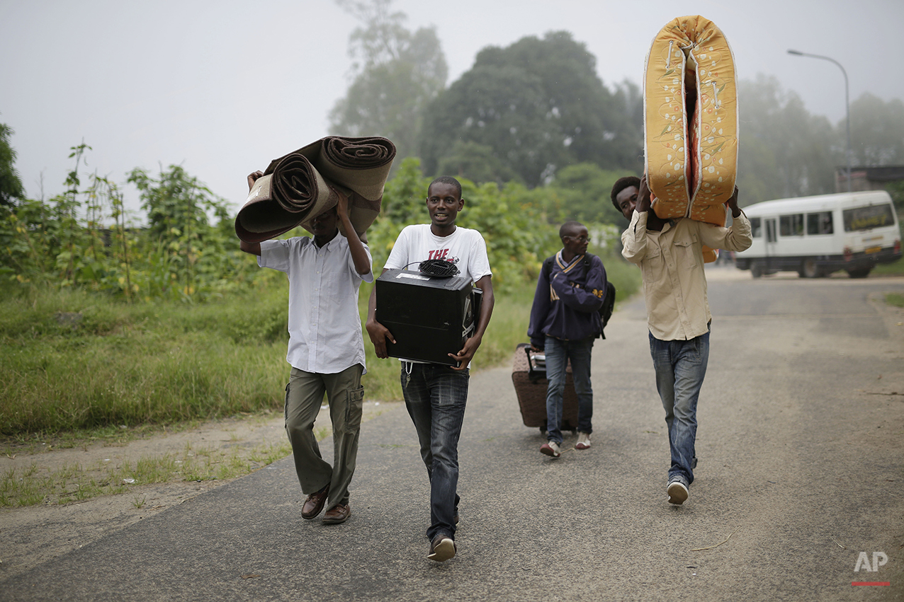  Students carry their belongings as they leave the Kiriki University campus in Bujumbura, Burundi Thursday, April 30, 2015, after the government issued and ordered for all campuses to close down. Bujumbura has been hit by street protests since Sunday