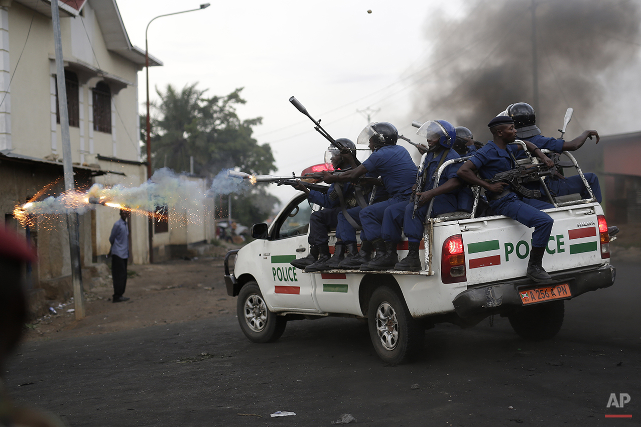  Burundi riot police fire tear gas as they chase demonstrators during clashes in Bujumbura, Burundi, Wednesday April 29, 2015. Protesters were again on the streets Wednesday, angry over the Burundian president's third term bid that they say is uncons