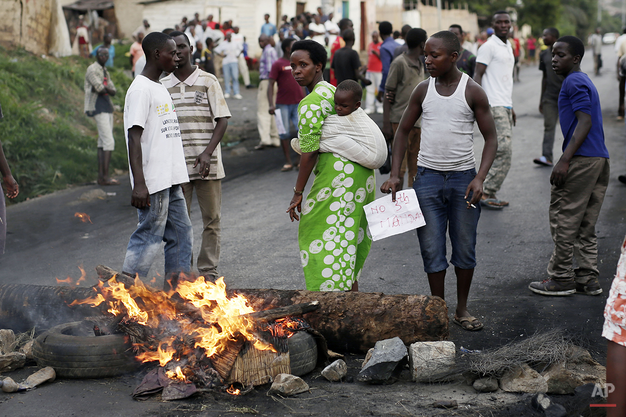  A woman carrying her baby joins demonstrators on a barricade during clashes in Bujumbura, Burundi, Wednesday April 29, 2015. Protesters were again on the streets Wednesday, angry over the Burundian president's third term bid that they say is unconst