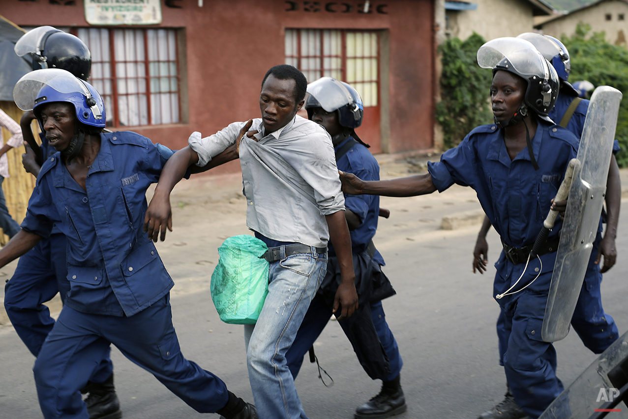  Burundi riot police detain a man suspected of throwing stones during clashes in the Musaga district of Bujumbura, Burundi, Tuesday April 28, 2015. Anti-government street demonstrations continued for a third day after six people died in protests agai