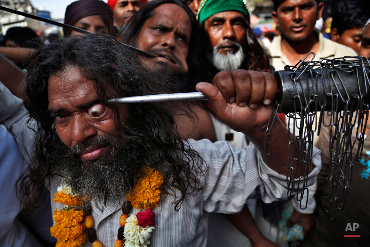 An Indian Muslim Sufi devotee uses a sharp object to
