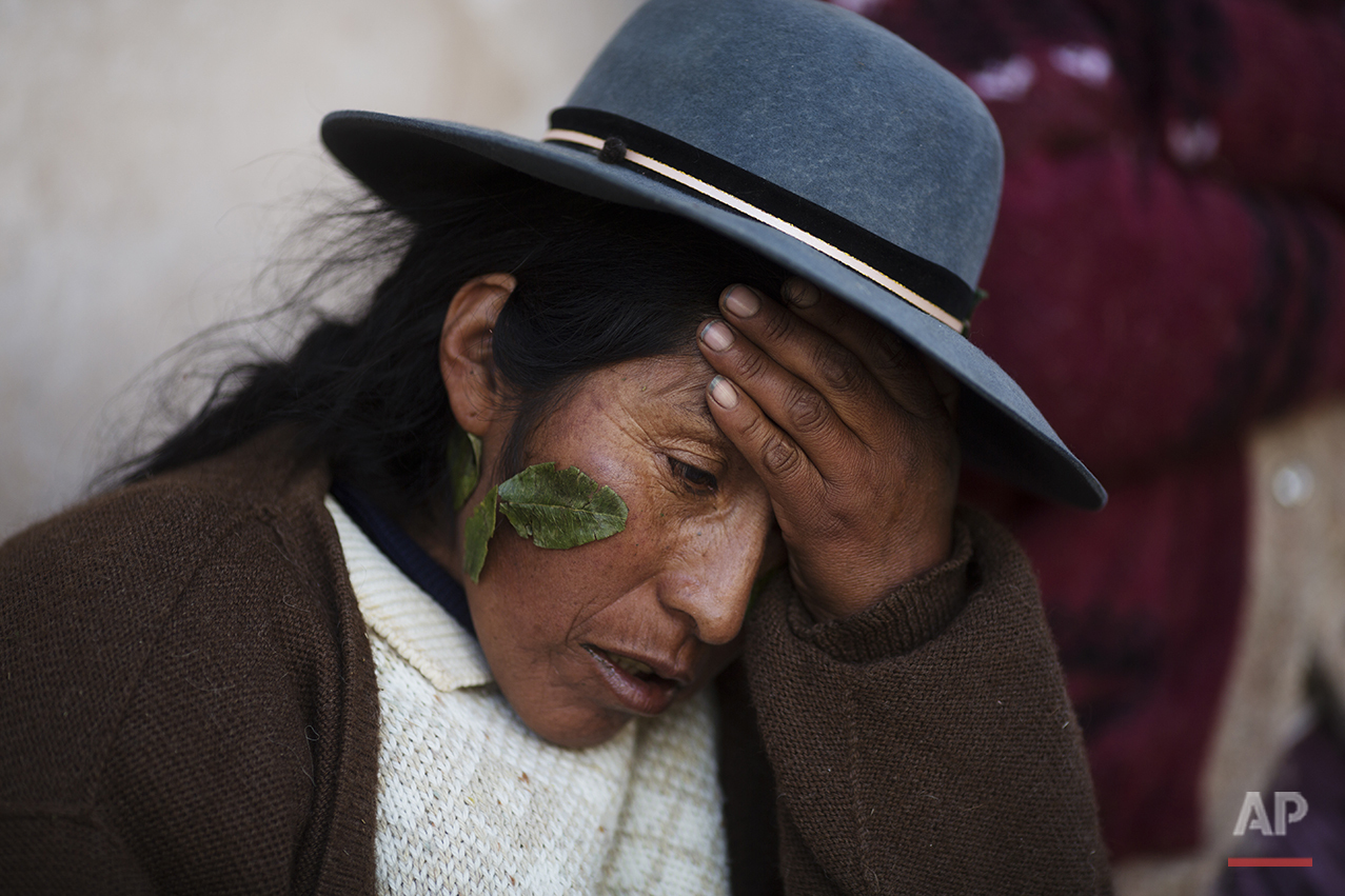  In this July 10, 2016 photo, Valeria Chuquibanca holds her head as she suffers a headache triggered by the heat reflected from the snow, one day after a heavy snow in San Antonio de Putina in the Puno region of Peru. Valeria said that sticking coca 
