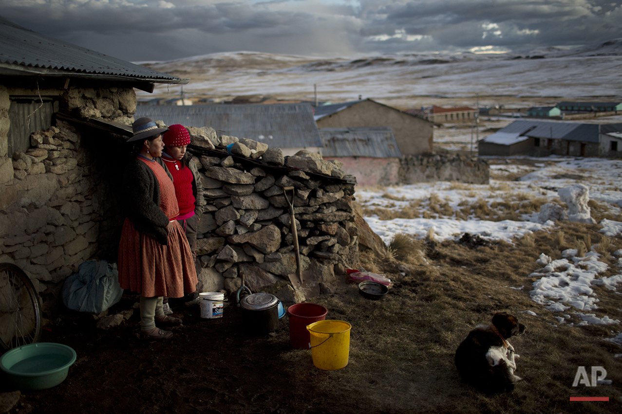  In this July 9, 2016 photo, Rosa Carcabusto and her daughter Maria Luque stand outside their home before cooking a dinner soup of wheat and dried potatoes, in San Antonio de Putina in the Puno region of Peru. Poverty has driven many farmers' childre