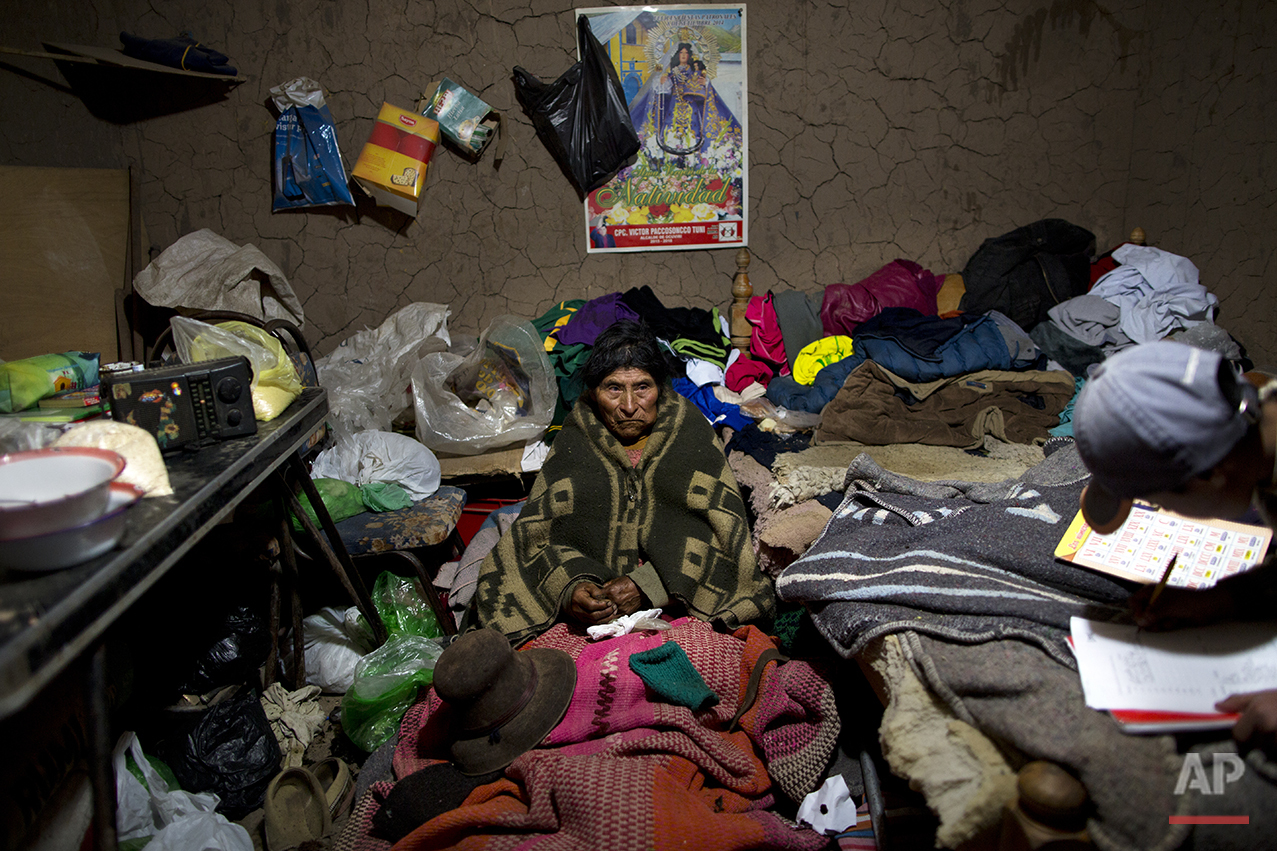  In this July 11, 2016 photo, Vicentina Javier rests inside a relative's adobe home as she recuperates from a respiratory illness in San Antonio de Putina in the Puno region of Peru. Authorities relocated Vicentina, 77, from her home to this village 