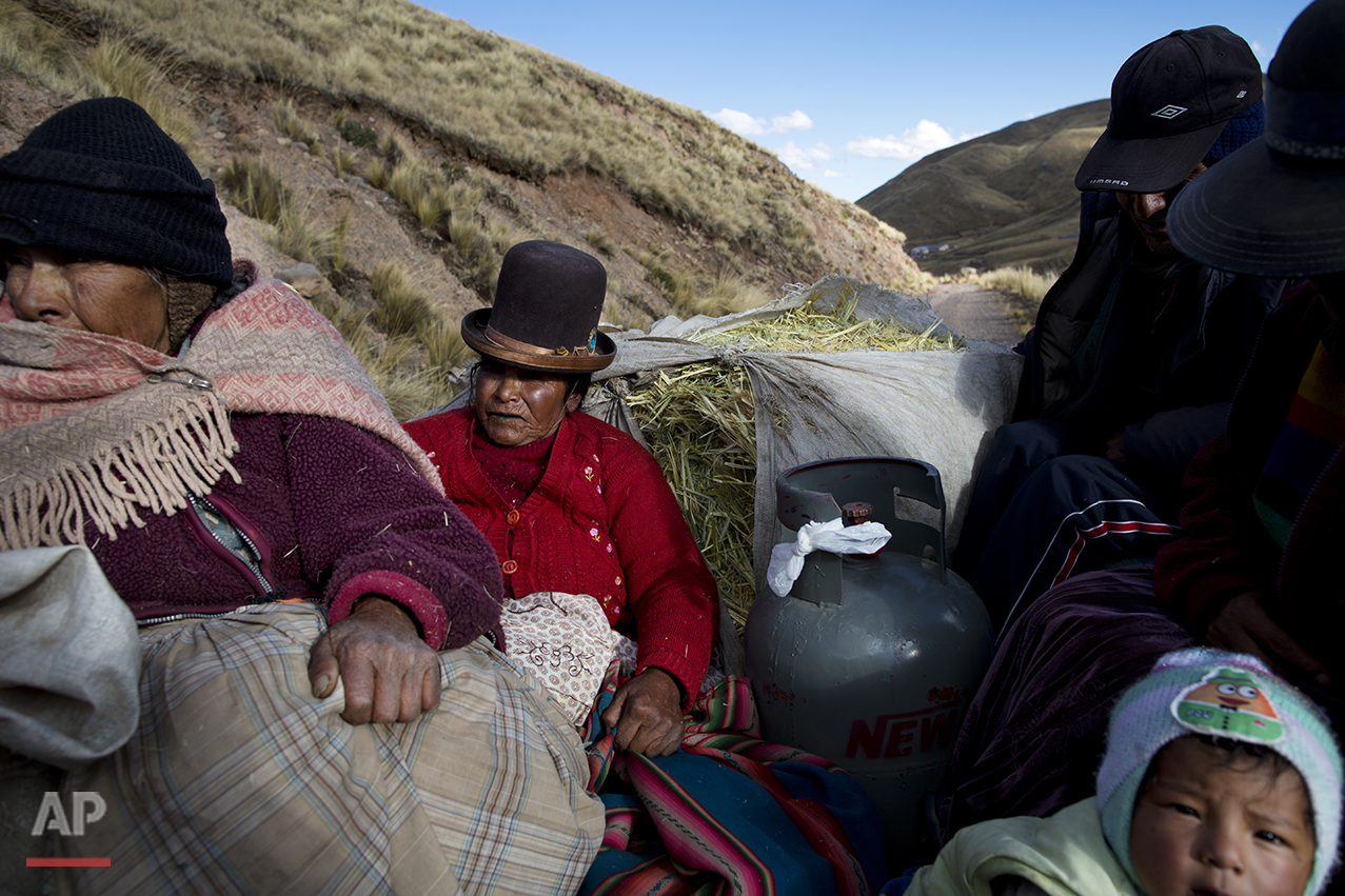  In this July 10, 2016 photo, camelid breeders ride in the back of a pick-up tuck with cooking gas and oats for their alpacas and sheep, as they return to their village of San Antonio de Putina in the Puno region of Peru. The passengers got the 30 mi