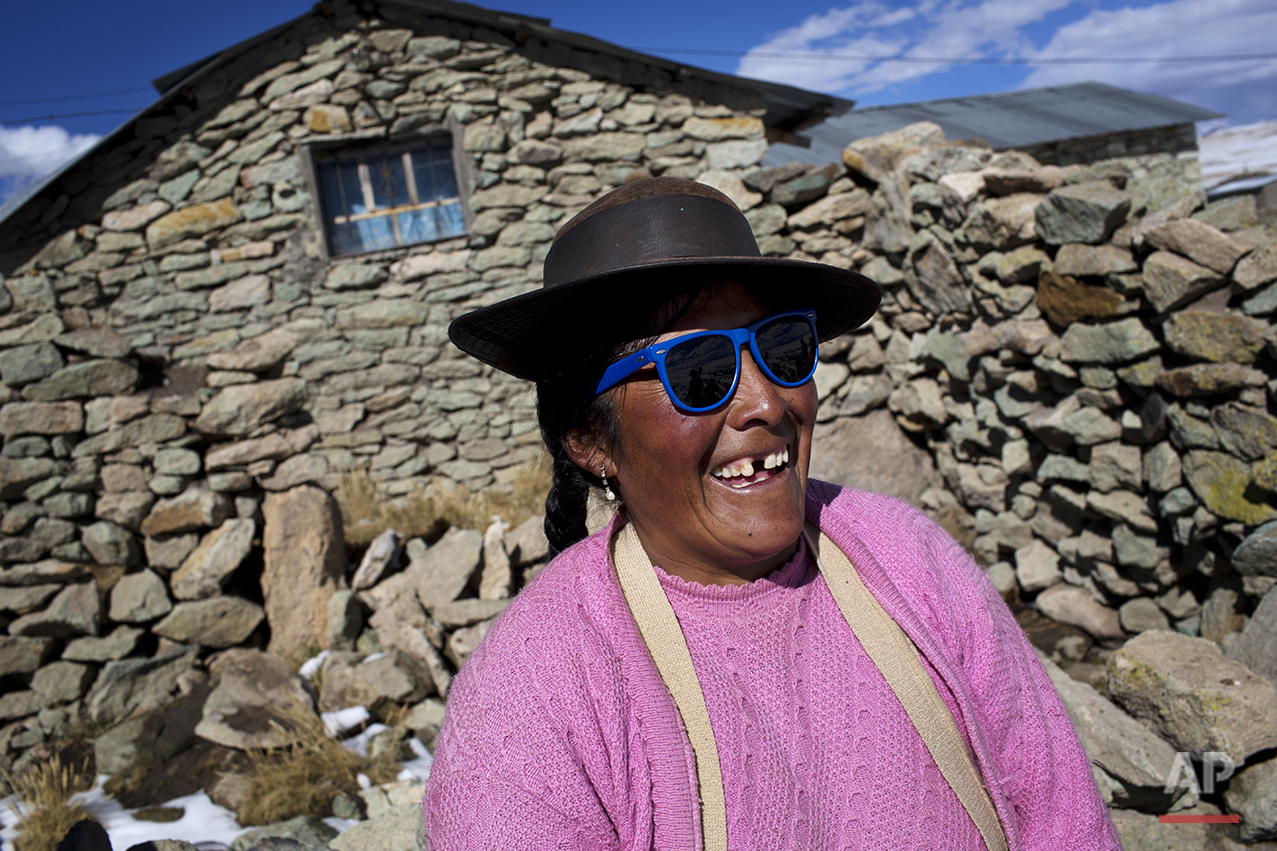  In this July 9, 2016 photo, Cecilia Callo Mamani laughs as her neighbors joke about her sunglasses in San Antonio de Putina in the Puno region of Peru. Mamani said she wears them to protect her eyes from the snow's strong reflection. (AP Photo/Rodri