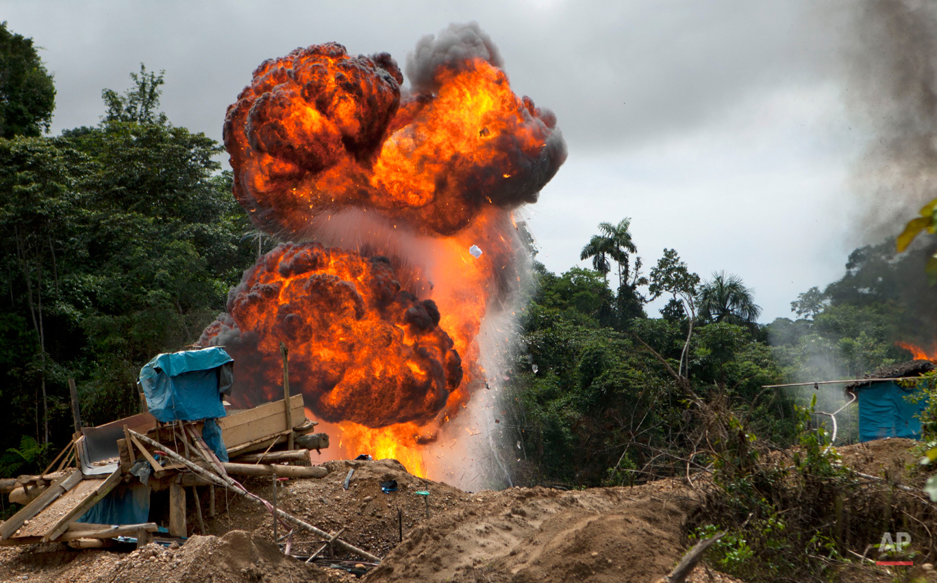 In this Wednesday, April 30, 2014 photo, gasoline used for illegal mining burns as it is destroyed by authorities in the Huepetuhe district of Peru's Madre de Dios region. (AP Photo/Rodrigo Abd)