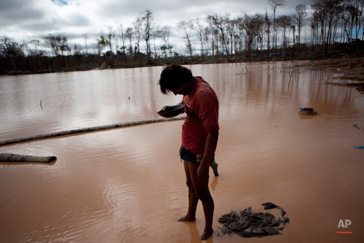 In this May 3, 2014 photo, a miner roughly estimates his handful of gold he mined, after working for over 24-hours, in La Pampa in Peru's Madre de Dios region. (AP Photo/Rodrigo Abd)