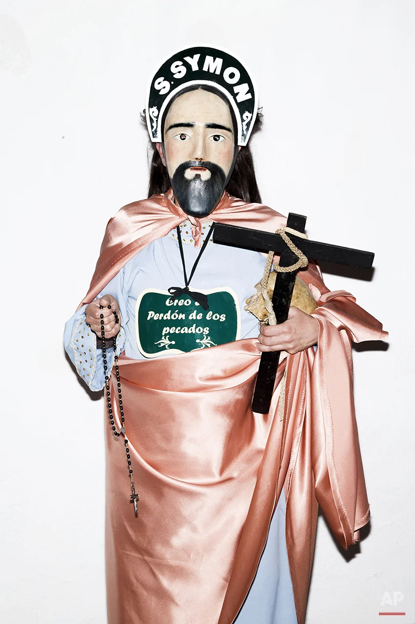 A penitent poses for a picture dressed with typical Apostle dress, holding a Cross in one hand and an ancient human skull from a unidentified person, before the Holy Week procession by the 'Nuestro Padre Jesus Nazareno and Nuestra Señora de la Piedad' brotherhood in Iznajar, Spain, Friday, April 3, 2015. Among the characters taking part in the procession are the “Brotherhood of the Apostles,” represented, as the name suggests, by 12 townsfolk who don a distinctive mask, dress up in robes, carry a rosary and process behind an urn carved in the shape of the “Dead Christ.” Each apostle carries a human skull, a black cross and words taken from the Roman Catholic credo. (AP Photo/Daniel Ochoa de Olza)