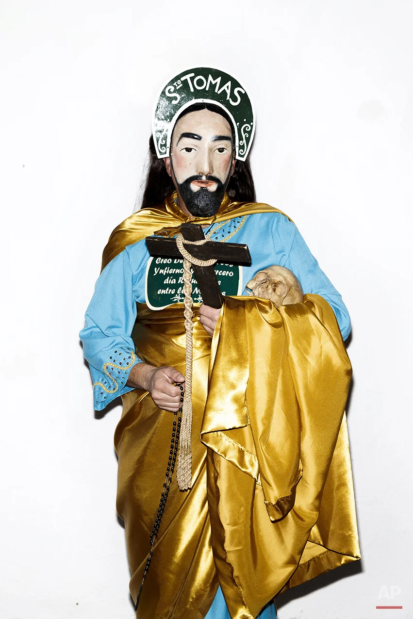 A penitent poses for a picture dressed with typical Apostle dress, holding a Cross in one hand and an ancient human skull from a unidentified person, before the Holy Week procession by the 'Nuestro Padre Jesus Nazareno and Nuestra Señora de la Piedad' brotherhood in Iznajar, Spain, Friday, April 3, 2015. Among the characters taking part in the procession are the “Brotherhood of the Apostles,” represented, as the name suggests, by 12 townsfolk who don a distinctive mask, dress up in robes, carry a rosary and process behind an urn carved in the shape of the “Dead Christ.” Each apostle carries a human skull, a black cross and words taken from the Roman Catholic credo. (AP Photo/Daniel Ochoa de Olza)