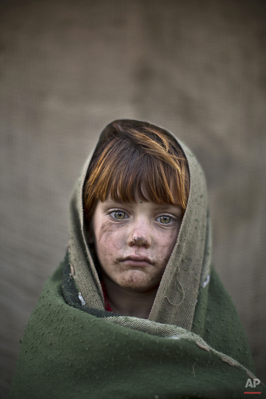  In this Friday, Jan. 24, 2014 photo, Afghan refugee girl, laiba Hazrat, 6, poses for a picture, while playing with other children in a slum on the outskirts of Islamabad, Pakistan. For more than three decades, Pakistan has been home to one of the wo