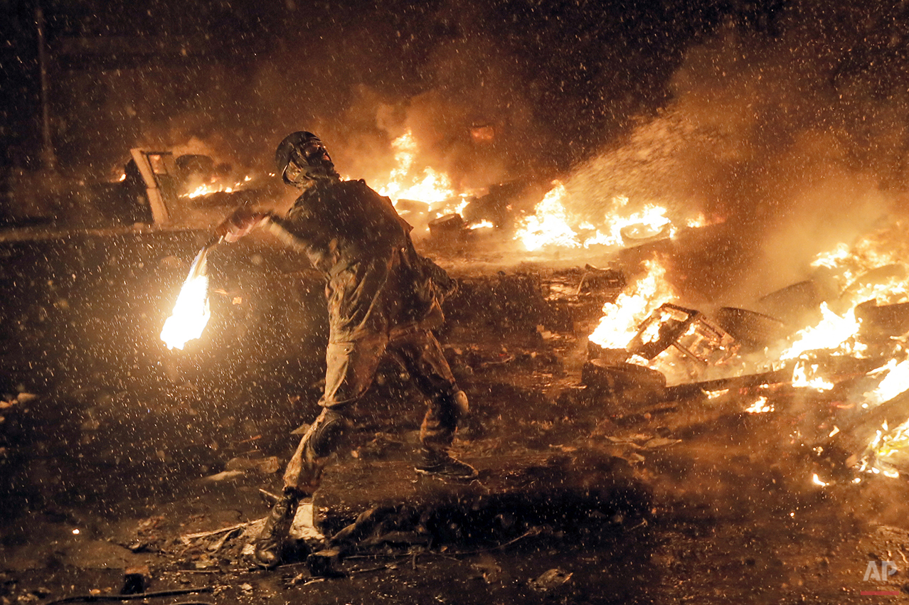  A protester throws a Molotov cocktail during clashes with police in central Kiev, Ukraine, Wednesday, Jan. 22, 2014. Three people have died in clashes between protesters and police in the Ukrainian capital Wednesday, according to medics on the site,