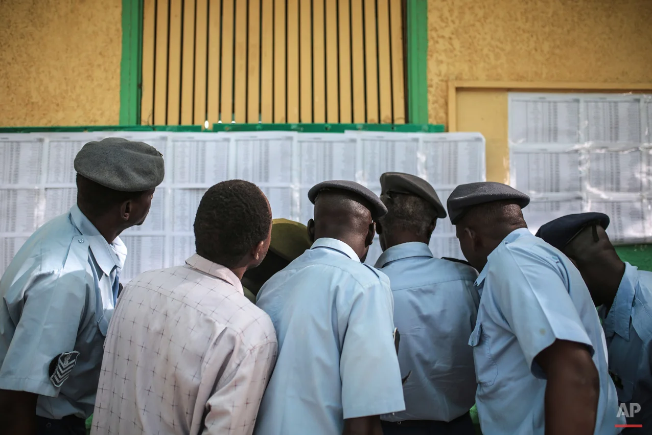  Members of the Sudanese security forces look for their names on a voters list outside a polling station where they are due to vote, on the first day of Sudan's presidential and legislative elections, in Khartoum, Sudan, Monday, April 13, 2015. (AP P