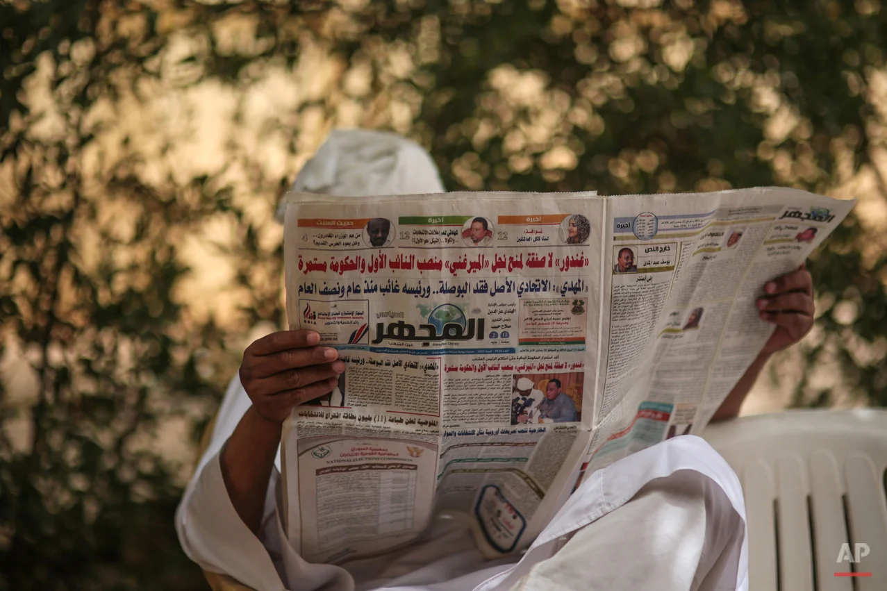  In this Saturday, April 11, 2015 photo, a man reads a newspaper during a sit-in organized by Sudanese opposition parties at the headquarters of Umma, one of Sudanís biggest opposition parties, in Khartoum, Sudan, to denounce the upcoming presidentia
