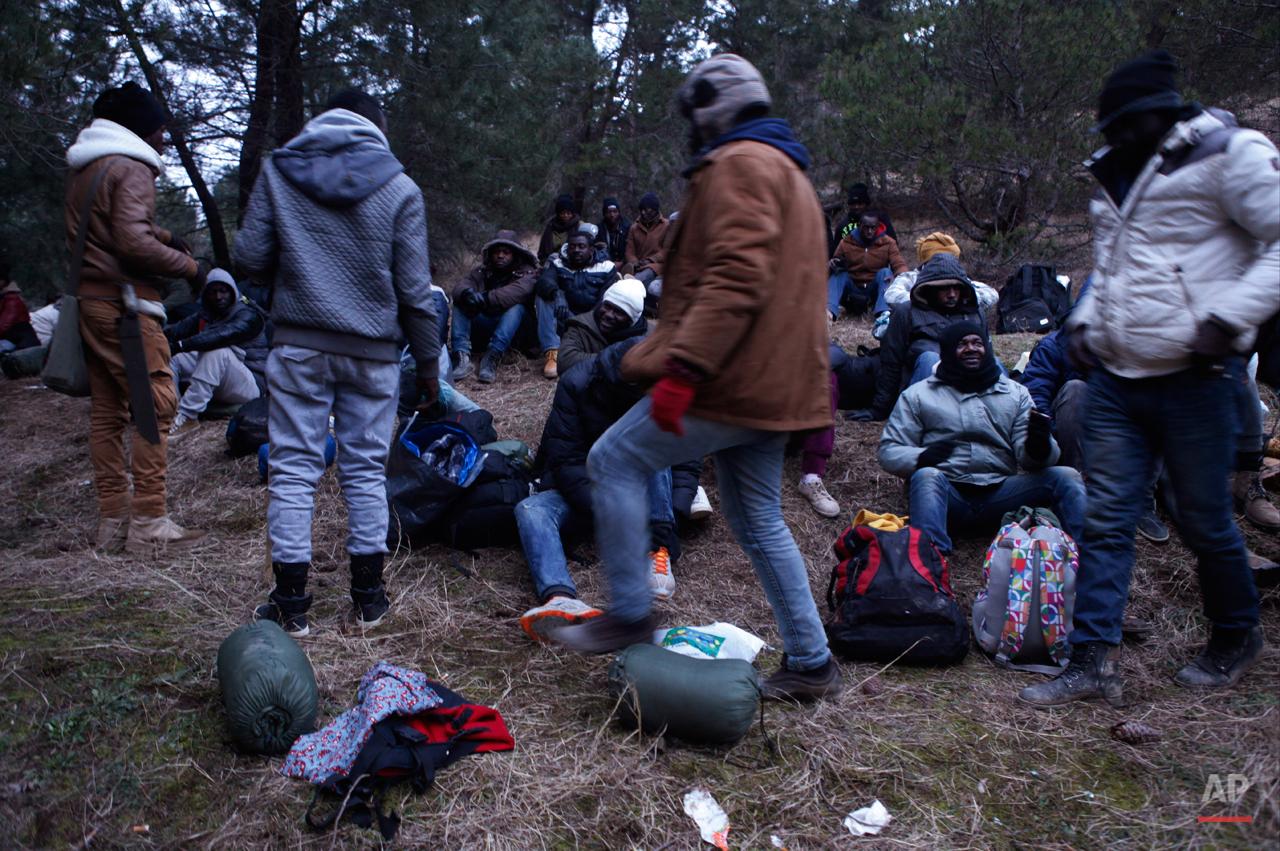  In this Monday, March 2, 2015 photo West African migrants prepare at dusk to march through the night near the town of Gevgelija, Macedonia, after crossing the border from Greece.  The tide of hopeful migrants pours through the vulnerable 'back-door'