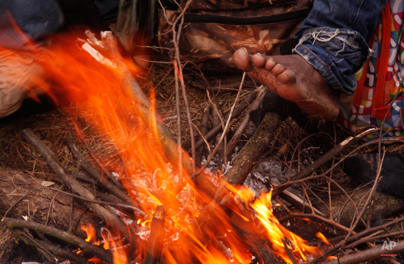  In this Friday, March 6, 2015 photo West African migrants warm themselves on a bonfire near Gradsko, Macedonia.  The tide of hopeful migrants pours through the vulnerable 'back-door' countries in the hope of entering the 28-nation European Union, an