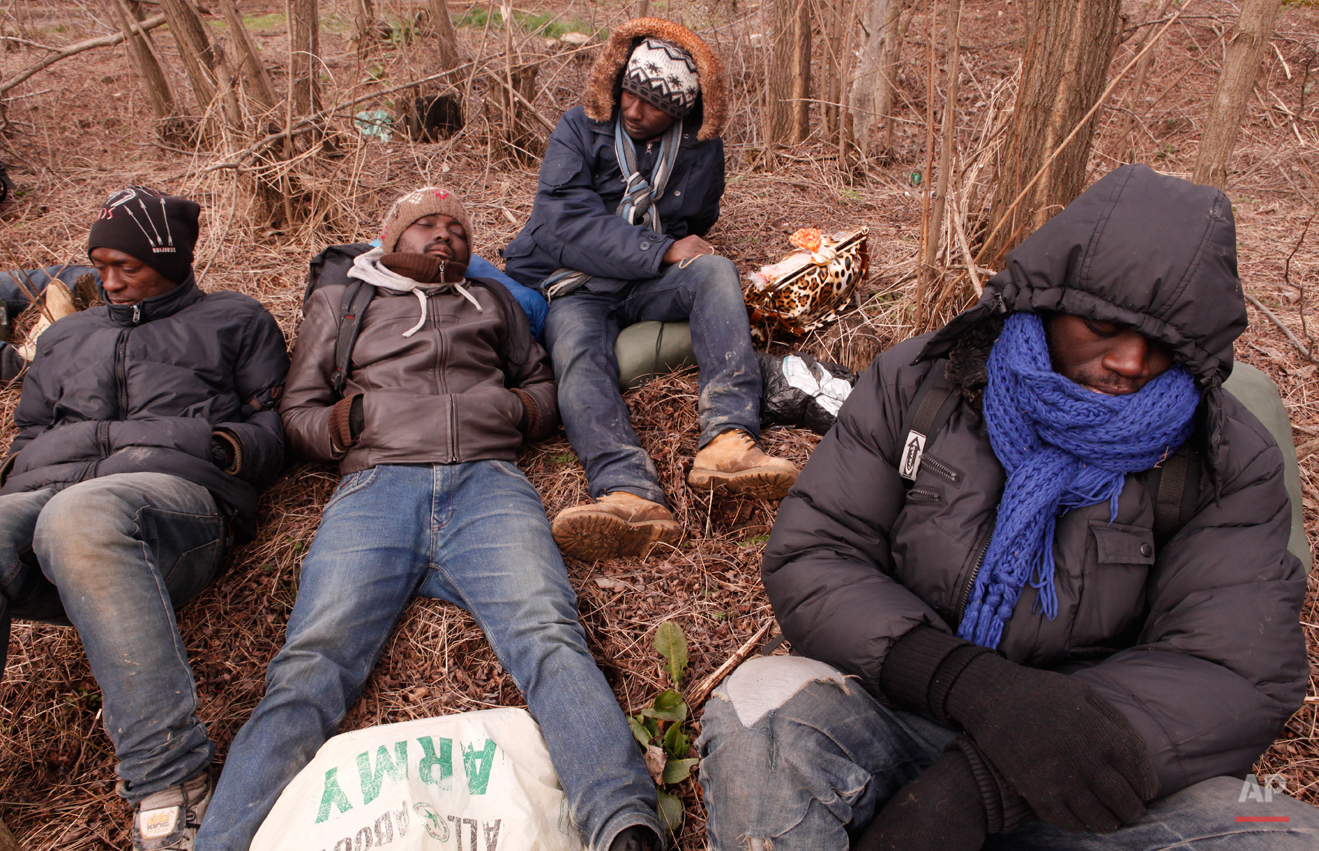  In this Friday, March 6, 2015 photo West African migrants sit exhausted after a night of heavy rain and hail that destroyed their tents near Gradsko, Macedonia.  The tide of hopeful migrants pours through the vulnerable 'back-door' countries in the 