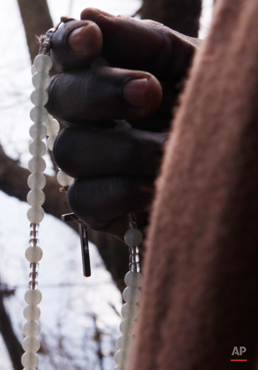  In this Tuesday, March 3, 2015 photo Hilarion Charlemagne prays near the village of Marvintsi, Macedonia.  The tide of hopeful migrants pours through the vulnerable 'back-door' countries in the hope of entering the 28-nation European Union, and alth