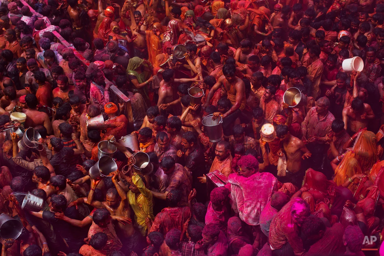 Indian Hindu devotees walk with empty buckets after emptying the contents on women participating in "Huranga," during celebrations marking Holi, the Hindu festival of colors, at the Baldev Temple in Dauji, 180 kilometers (113 miles) south of New Delhi, India, Saturday, March 7, 2015. During Huranga women playfully hit men with cloth whips as men drench them with buckets of colored water. (AP Photo/Bernat Armangue)