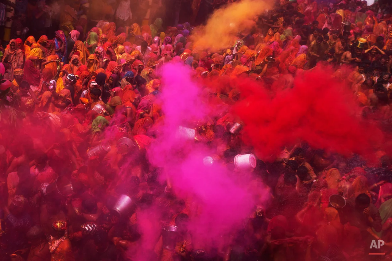 Colored powder and water is thrown as Hindu devotees participate in "Huranga," during celebrations marking Holi, the Hindu festival of colors, at the Baldev Temple in Dauji, 180 kilometers (113 miles) south of New Delhi, India, Saturday, March 7, 2015. During Huranga women playfully hit men with cloth whips as men drench them with buckets of colored water. (AP Photo/Bernat Armangue)