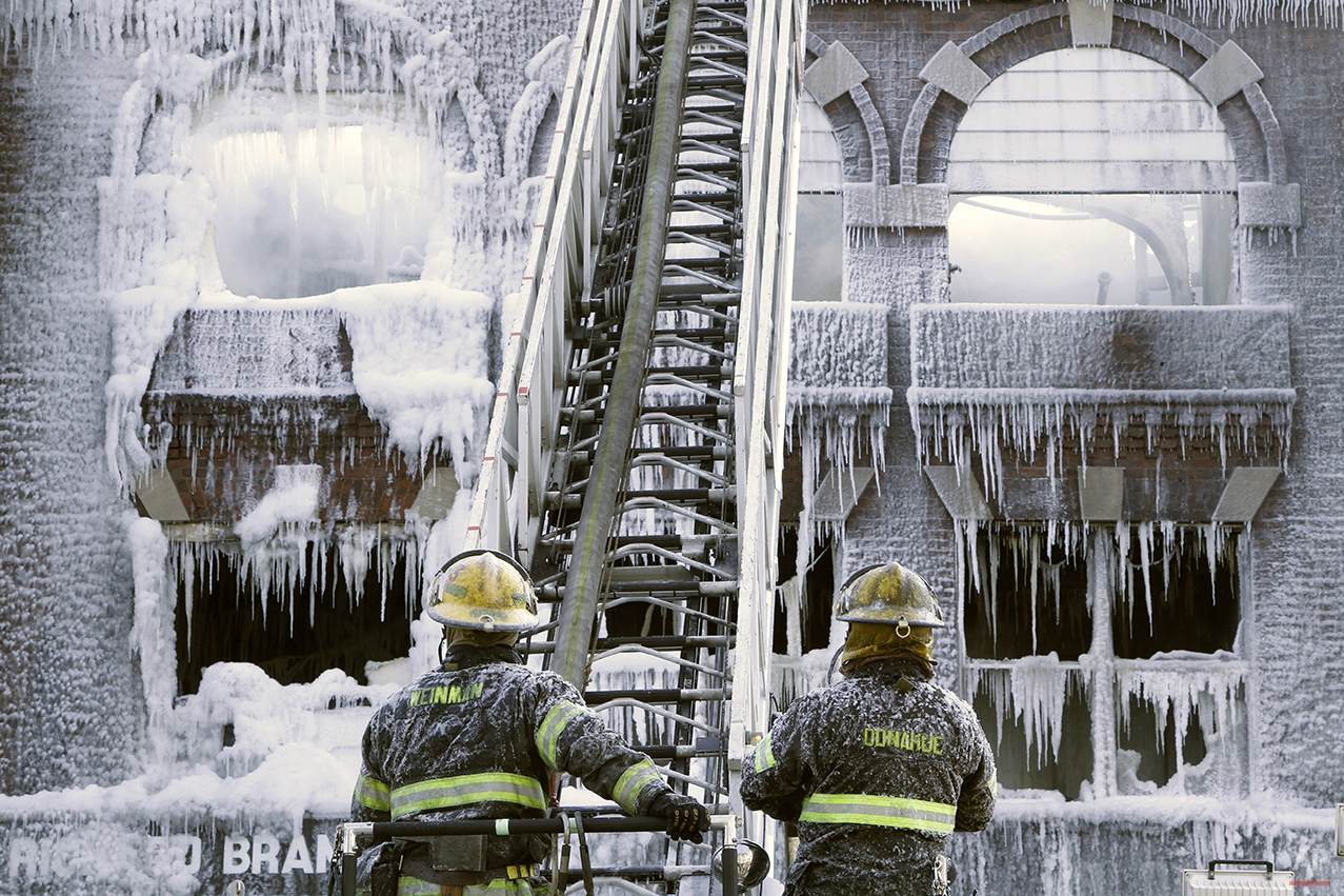  Philadelphia firefighters work the scene of an overnight blaze in west Philadelphia, Monday Feb. 16, 2015, as icicles hang from where the water from their hoses froze. Bone-chilling, single digit temperatures have gripped the region, prompting the c