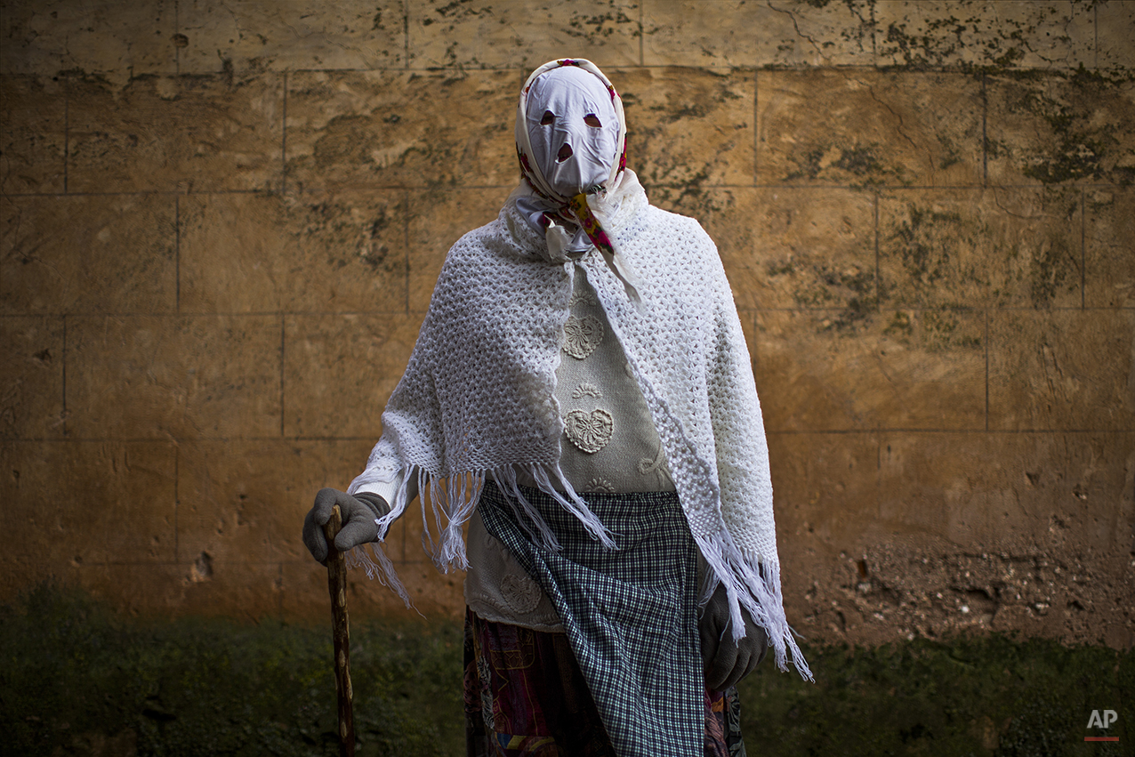  A reveler wearing a costume poses for a picture during a traditional carnival celebration in the small village of Luzon, Spain, Saturday, Feb. 14, 2015. Preserved records from the 14th century document Luzon's carnival, but the real origin of the tr