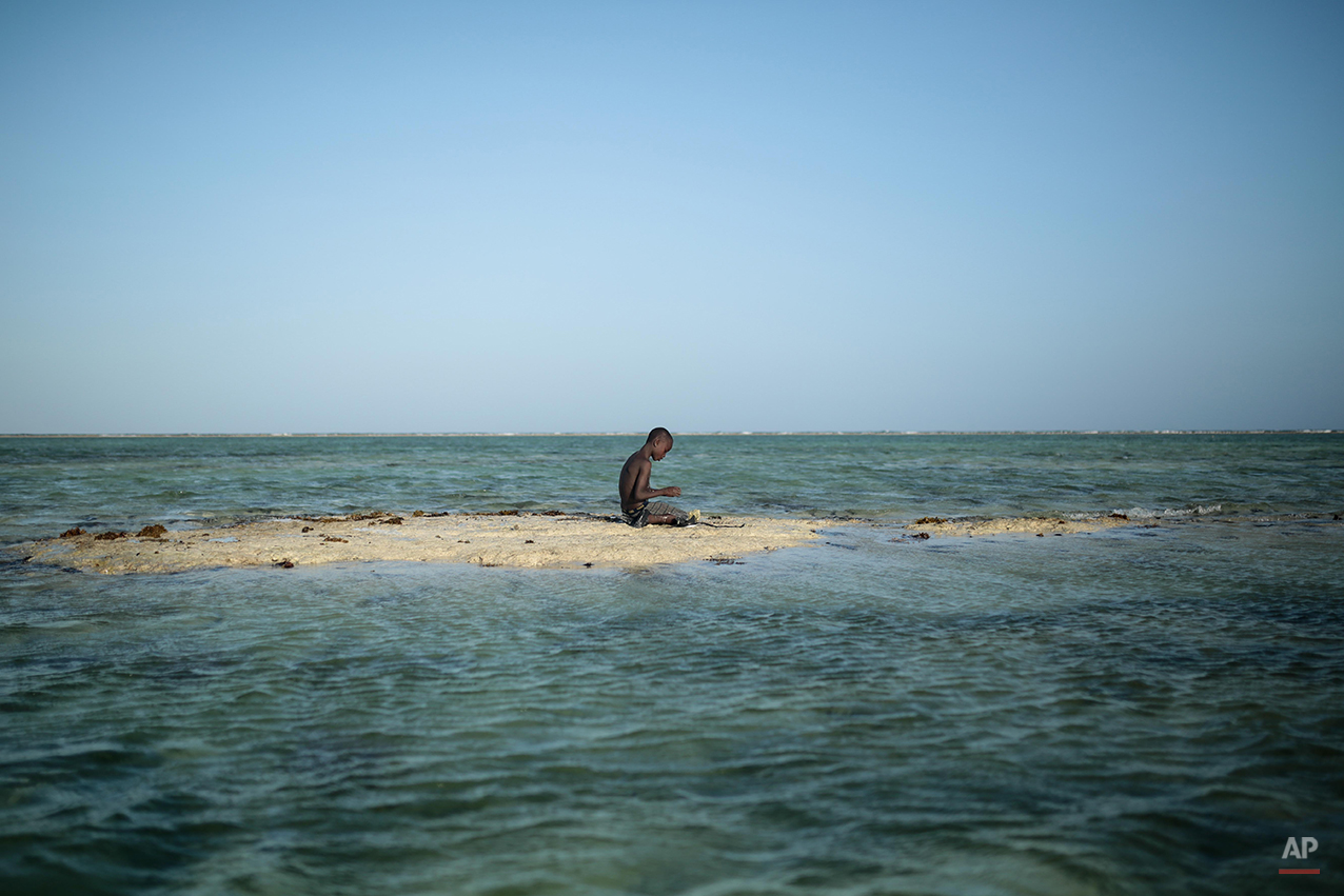  A young Zanzibari fisherman takes a break on a sandbank in the Indian Ocean off the coast of Matemwe village, northeastern Zanzibar, Tanzania, Wednesday, Jan. 28, 2015. (AP Photo/Mosa'ab Elshamy) 