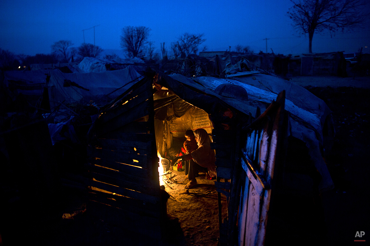  Pakistani Sughar Ramadan, 38, and her daughters Shameem, 7 and Samreen, 2, sit around a fire to warm themselves from the night cold inside their makeshift home in a slum in Islamabad, Pakistan, Friday, Feb. 13, 2015. (AP Photo/Muhammed Muheisen) 