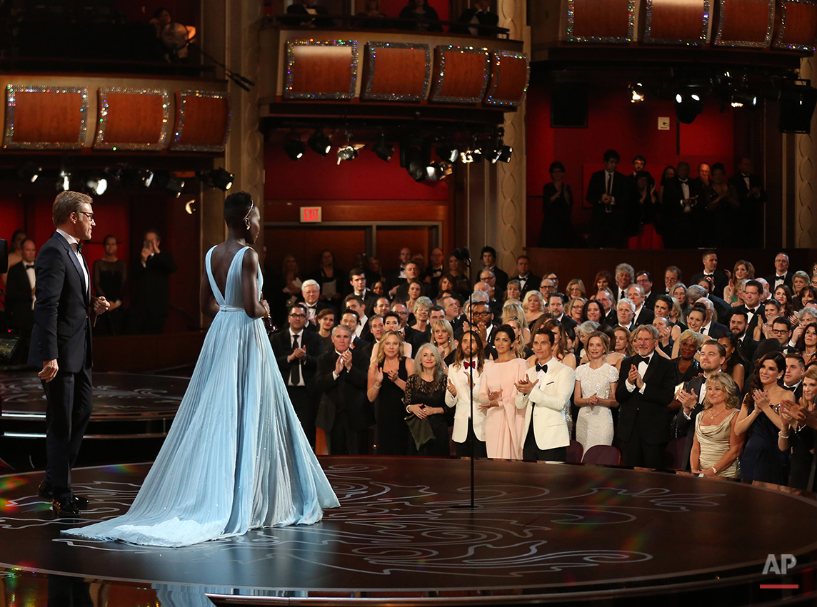  Lupita Nyong’o receives a standing ovation as she accepts the award for best actress in a supporting role for "12 Years a Slave" during the Oscars at the Dolby Theatre on Sunday, March 2, 2014, in Los Angeles.  (Photo by Matt Sayles/Invision/AP) 