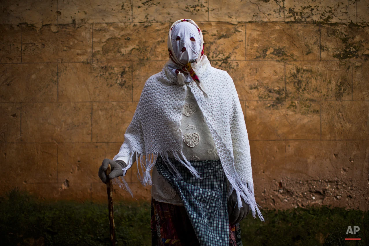 In this photo taken on Saturday, Feb. 14, 2015 a reveller wearing a costume, poses for a picture during a traditional carnival celebration in the small village of Luzon, Spain. While Rio de Janeiro may boast the worldís most famous carnival, the festive period of masquerades and wild and colorful costumes that precedes the Christian religious season of Lent is also a permanent and popular fixture for celebration in Spain and Portugal, with each country having its own strange and unique way of doing it. In Spainís central town of Luzon, men covered in oil and soot wear bull horns and cowbells to represent the devil. Records of Luzonís carnival date as far back as the 14th century although it is believed to be much older. (AP Photo/Andres Kudacki)